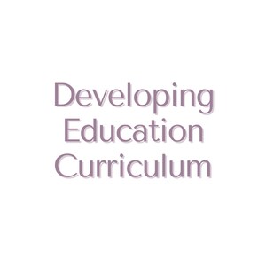 May include: A white background with the text "Developing Education Curriculum" in purple. A notepad with a pink pen is in the top left corner and a tablet with a light blue and yellow design is in the bottom right corner.