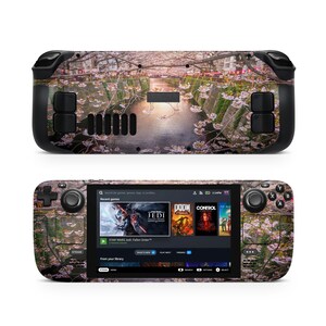 Op de afbeelding: Een zwarte handheld-gameconsole met een bloemenontwerp. Het scherm toont een menu met gametitels zoals "Star Wars Jedi: Fallen Order", "DOOM" en "Control".