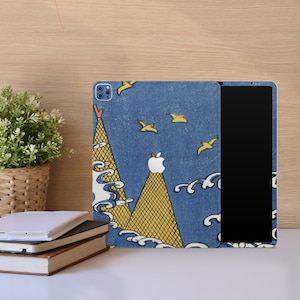 Può includere: Una custodia per iPad blu e gialla con un design a montagna e uccelli. La custodia è compatibile con l'iPad Pro da 12,9 pollici.