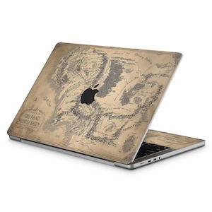 May include: A laptop with a map design. The map is in shades of brown and beige, with intricate details and text that reads "THE RAAD MINTLE EARTH". The laptop has a black Apple logo.