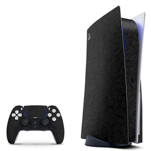 May include: A black PlayStation 5 console with a black and white patterned design. The console is standing upright and has a blue light on the side. A black PlayStation 5 controller is also shown.