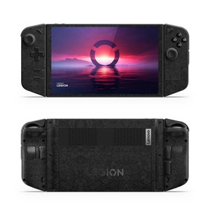Puede incluir: Una consola de juegos portátil negra con una superficie texturizada. La pantalla muestra una escena de puesta de sol con un logotipo circular. La consola tiene botones y una palanca de mando en los lados. El texto "Lenovo Legion" es visible en la parte inferior de la pantalla.