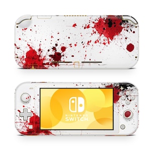 May include: White Nintendo Switch Lite console with a red splatter design. The console features a screen with the Nintendo Switch logo and a yellow and orange background. The top and bottom of the console are visible.