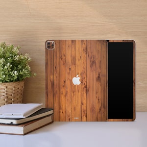 May include: A brown wood-grain iPad case with a black screen and a white Apple logo. The case has a textured wood-grain pattern.