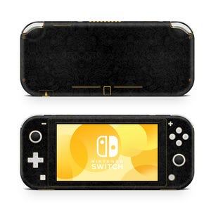 May include: Black Nintendo Switch Lite console with a textured black and gold design. The console has a yellow screen with the Nintendo Switch logo and text.