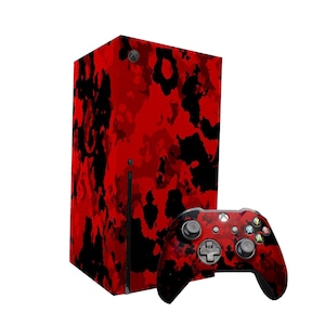 Könnte beinhalten: Eine Xbox Series X Konsole und ein Controller in rot-schwarzem Tarnmuster. Die Konsole ist hoch und rechteckig mit einer schwarzen Frontplatte. Der Controller ist ein Standard-Xbox-Controller mit schwarzer Basis und rot-schwarzen Tarnmustern.