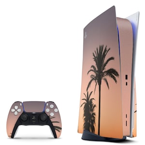 May include: A rose gold PlayStation 5 console with a sunset and palm tree design. The console is shown with a matching rose gold controller.