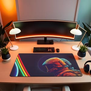 May include: A gaming desk setup featuring a large curved monitor, keyboard, mouse, and a custom mousepad. The mousepad has a dark background with a colorful design and a futuristic helmet graphic. Two desk lamps and potted plants flank the monitor.