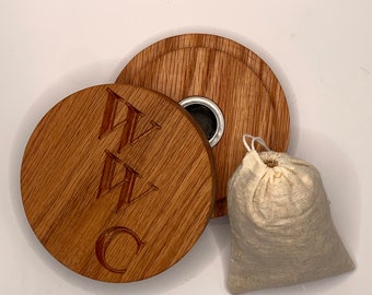 May include: A wooden box with a lid, engraved with the initials "W.C." and a small hole in the lid. A small white cloth bag is next to the box.