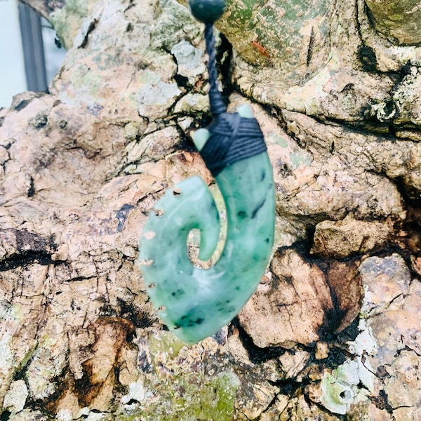 Pendentif hameçon en jade indonésien, dans la culture maorie, le Hei Matau représente la prospérité, la fertilité et le passage sûr sur l'eau.