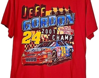May include: Red t-shirt featuring a graphic of a race car with the text "JEFF GORDON 24 2001 CHAMP" in blue, yellow, and white. The shirt also includes the text "NASCAR Winston Cup Series".