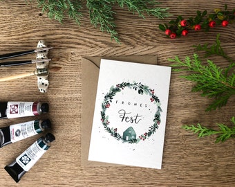 Weihnachtskarte „frohes Fest“ / Karte zu Weihnachten / Winterlicher Watercolorkranz mit roten Beeren Eukalyptus und Häuschen auf A6 Karte
