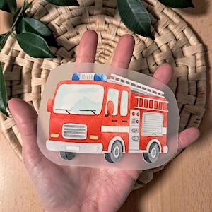 Könnte beinhalten: Ein roter Feuerwehraufkleber mit einer weißen Leiter, blauen Lichtern und schwarzen Rädern. Der Aufkleber ist eine Cartoon-Illustration eines Feuerwehrautos, ideal für Kinderbasteln oder Dekorationen.