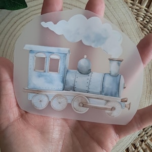 Könnte beinhalten: Aquarell-Illustration einer blauen Dampflokomotive mit einer weißen Rauchwolke. Der Zug hat zwei Fenster und einen Schornstein. Das Bild hat einen transparenten Hintergrund.