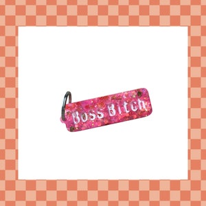 May include: Pink glitter keychain with a silver ring and the text "Boss Bitch" in white lettering.