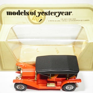 May include: A red toy car with a black top, in its original packaging. The box is labeled "models of yesteryear" and has instructions for ages 8 and over.