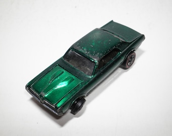 May include: A green die-cast toy car model of a 1967 Mercury Cougar.