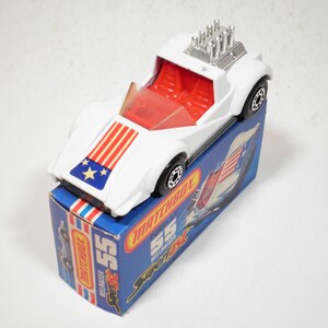 May include: White Matchbox Superfast #55 'Hellraiser' toy car with red and blue American flag design on the hood. The car is in its original box, which also features the American flag.