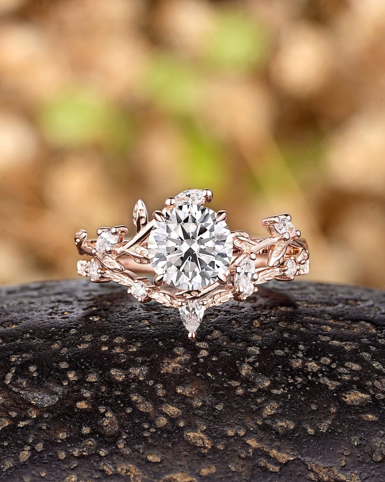 May include: A rose gold engagement ring with a large round center stone and smaller stones set in a delicate vine design.
