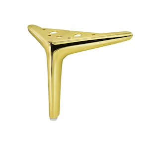 Könnte beinhalten: Goldfarbenes Möbelbein aus Metall mit dreieckiger Basis und abgerundetem, spitz zulaufendem Design. Das Bein hat einen weißen Kunststoff-Fußabdruck.