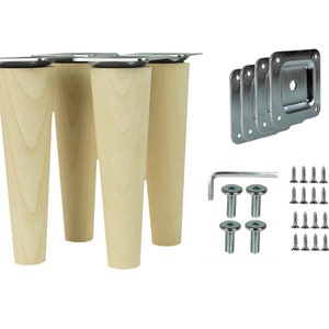 Könnte beinhalten: Ein Set aus vier Holzmöbelfüßen mit Metallmontageplatten, Schrauben, Bolzen und einem Inbusschlüssel. Die Beine sind hell und konisch. Hardware für die Möbelmontage ist enthalten.