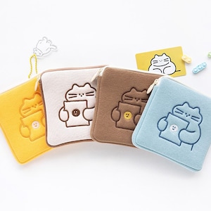 May include: Four small zippered pouches with a cat design. The pouches are in yellow, white, brown, and blue.