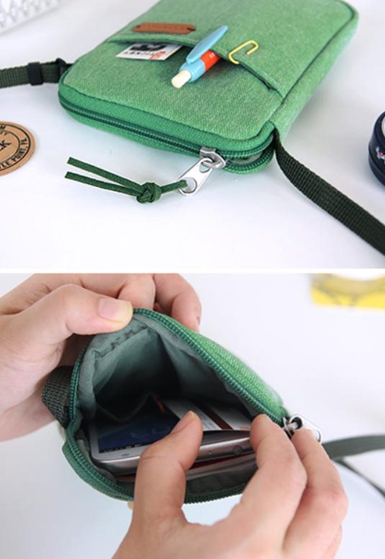 Puede incluir: Bolso bandolera de lona verde con cierre de cremallera y un peque&ntilde;o bolsillo delantero. El bolso tiene una correa verde oscuro y un peque&ntilde;o bol&iacute;grafo y clip decorativos. El interior del bolso es visible, con un smartphone.