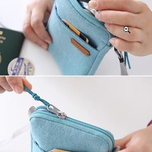 Puede incluir: Bolsa de mezclilla azul claro con cierre de cremallera y un peque&ntilde;o bolsillo frontal. La bolsa tiene una correa gris y una etiqueta de cuero. El tirador de la cremallera es turquesa. La bolsa est&aacute; abierta, revelando su contenido.