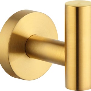 May include: Gold metal hook with a round base. The hook is designed for hanging items on a wall.