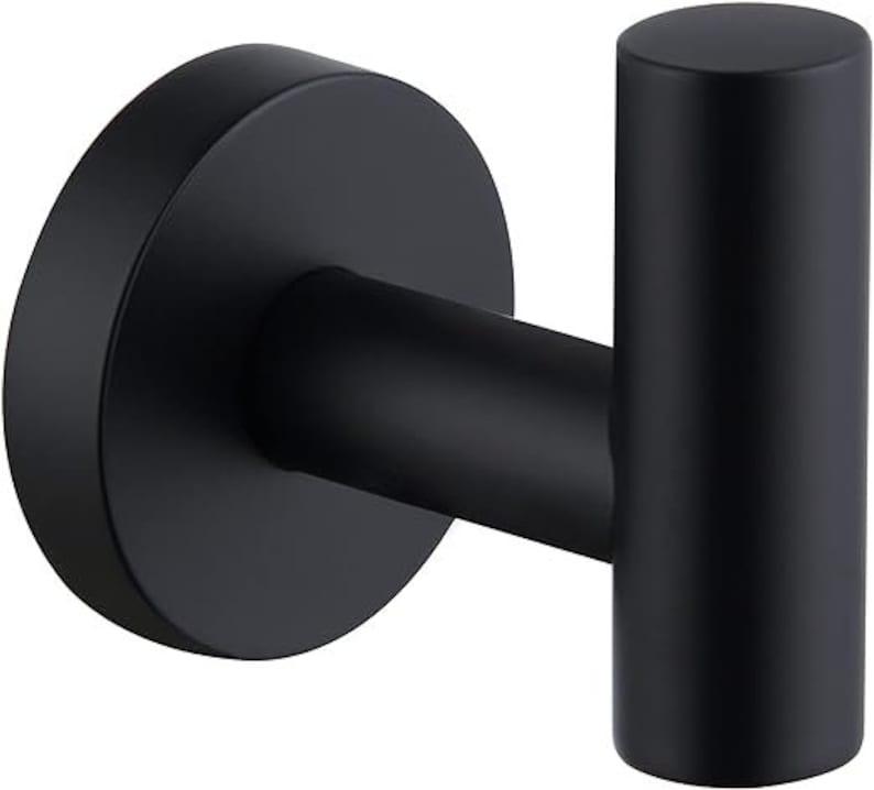 May include: A black metal hook with a round base. The hook is designed for hanging items on a wall.