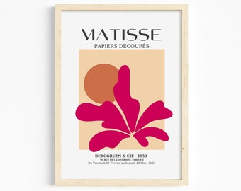 Puede incluir: Una impresión enmarcada de una obra de arte de Matisse titulada "Papiers Découpés" que presenta una forma rosa similar a una flor con un gran círculo naranja en el fondo. El texto "BERGGRUEN & CIE 1953 70, RUE DE L'UNIVERSITE, PARIS VII Du Vendredi 27 Février au Samedi 28 Mars 1953" está impreso en la parte inferior.