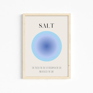 May include: A framed print with a blue gradient circle and the word "SALT" in black text. The quote "SHE TASTED THE SALT OF FREEDOM IN THE SEA, AND REVELED THE SUN" is printed below the circle.