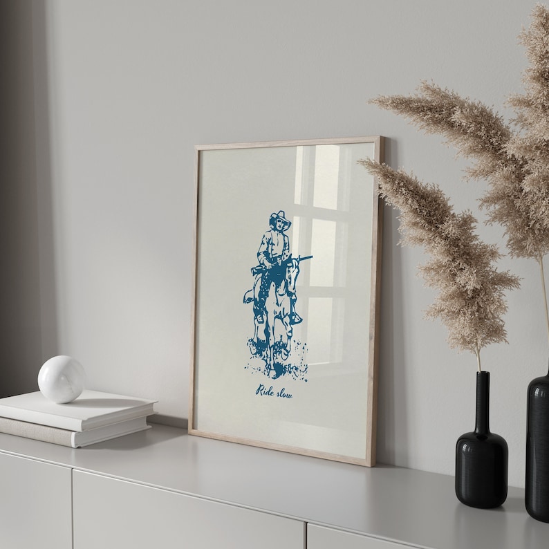 May include: A blue and white illustration of a cowboy riding a horse with the text "Ride slow" printed below the image.
