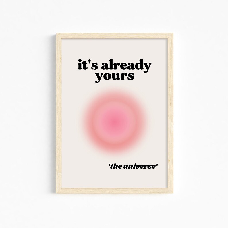 May include: A framed print with a pink and white gradient circle in the center. The text "it's already yours" is above the circle and "'the universe'" is below the circle.