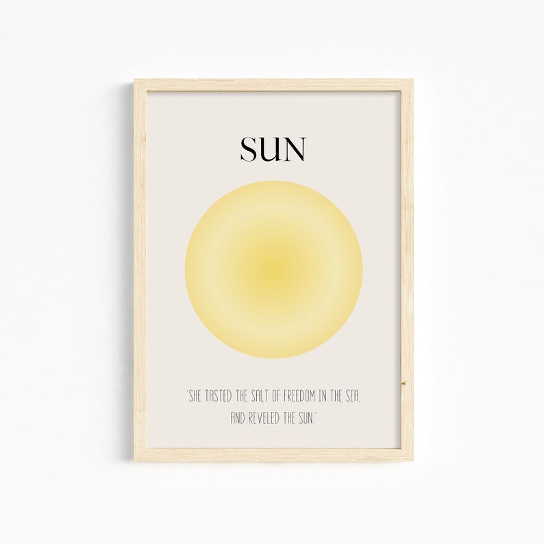 May include: A framed print with a yellow sun illustration and the text "SUN" in black. The quote "'SHE TASTED THE SALT OF FREEDOM IN THE SEA, AND REVELED THE SUN'" is printed below the sun.
