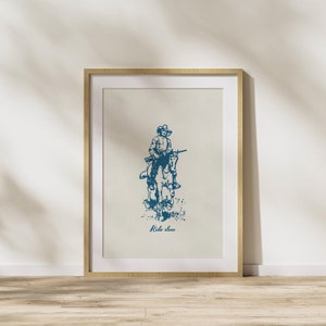 May include: A framed print with a blue illustration of a cowboy riding a horse. The text "Ride slow" is printed below the illustration.