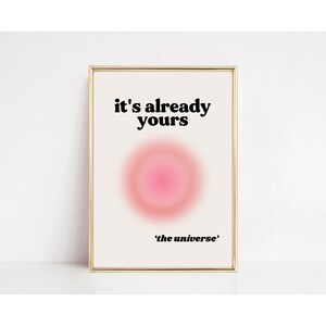 May include: A white framed print with a pink circle in the center and the text "it's already yours 'the universe'" in black.