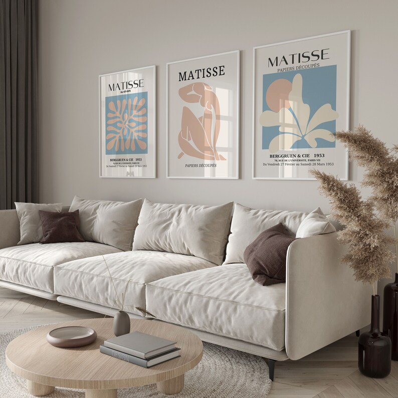 Pu&ograve; includere: Tre stampe d'arte incorniciate con il nome "MATISSE" e il titolo "PAPIERS D&Eacute;COUP&Eacute;S" in testo nero. Le stampe presentano disegni astratti in tonalit&agrave; di blu, rosa e bianco.