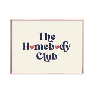 May include: A framed print with a cream background and navy blue text that reads "The Homebody Club" with two red hearts in the text.