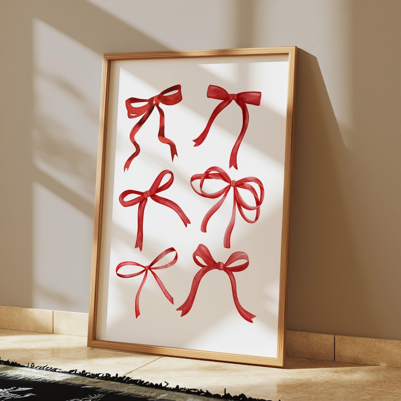 May include: A framed print with a white background and eight red watercolor bows.