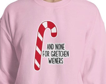 以下が含まれることがあります： 赤と白のキャンディーケーンのグラフィックと「And none for Gretchen Wieners」というテキストが書かれたピンク色のスウェットシャツ。