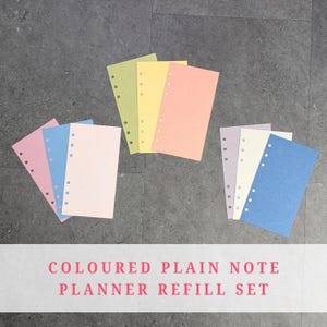 Könnte beinhalten: Eine Sammlung farbiger Planer-Nachfüllblätter in Rosa, Blau, Grün, Gelb, Pfirsich, Lavendel und Weiß. Jedes Blatt hat vorgestanzte Löcher zum Binden. Der Text "COLOURED PLAIN NOTE PLANNER REFILL SET" wird unten angezeigt.