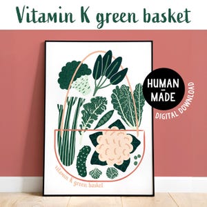 May include: A framed print featuring a stylized illustration of a basket filled with green vegetables. The artwork includes broccoli, kale, and cauliflower, with the text "Vitamin K green basket" at the top and bottom. A black circle with "Human Made Digital Download" is on the right.