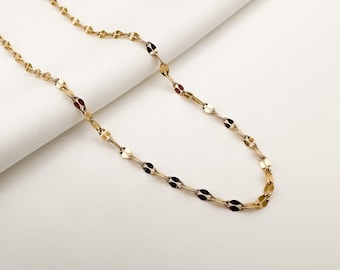 May include: A gold chain necklace with a delicate, oval-shaped link pattern. The chain is displayed on a white surface.
