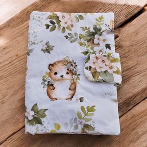 Protector de pañal personalizado hecho a mano con forma de erizo y conejo.