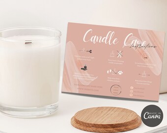 May include: A white candle in a clear glass jar with a wooden wick, accompanied by a candle care instruction card. The card is pink with white text and illustrations. A wooden coaster sits in front of the card and candle.