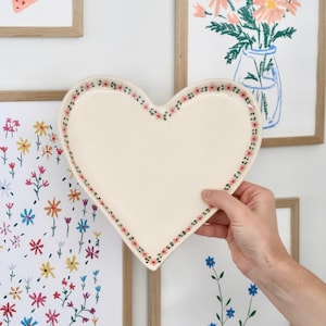 Plato grande artesanal con forma de corazón, de gres pintado a mano con motivos florales rosas, cerámica de estudio portuguesa.