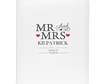 May include: White wedding guest book with the text "MR And MRS KILPATRICK" and the date "23.05.17" in black lettering. Two red hearts are on either side of the text "MRS".