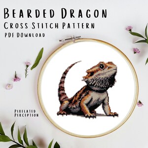May include: Cross stitch pattern of a bearded dragon, a type of lizard, in a hoop. The pattern is in shades of brown, beige, and white. The pattern is titled "Bearded Dragon Cross Stitch Pattern PDF Download".