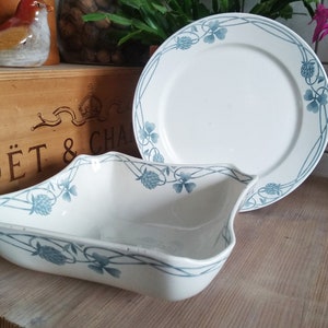 Puede incluir: Dos platos de cerámica blanca con un diseño de trébol azul. El plato más grande es un plato de servir redondo y el plato más pequeño es un tazón cuadrado.